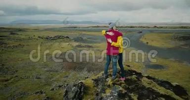 鸟瞰两个女人<strong>站在山顶</strong>上覆盖着苔藓和拥抱。 冰岛熔岩地游客